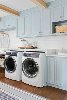 a washer and dryer in a laundry room with blue cabinets on the walls