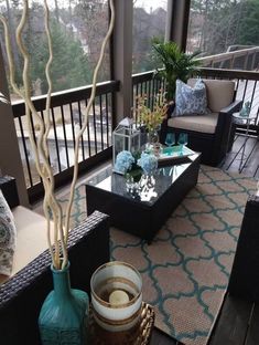 a living room with couches, chairs and a coffee table on a deck overlooking the water