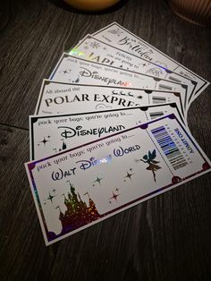 four disney world tickets sitting on top of a wooden table