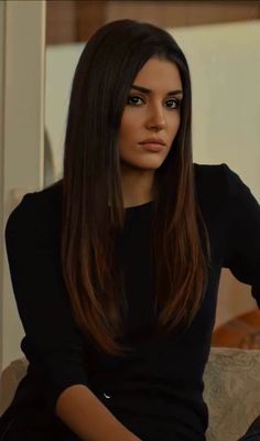 a woman with long hair sitting on a couch