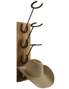 a hat rack with two hats hanging from it's sides and a cowboy hat on the other side