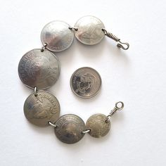 This bracelet can make a unique gift as it is made of various coins from different countries such as  Mexico, Costa Rica, Honduras, Nicaragua and Belize. The coins are all linked together with a hook closure in the end. The length of the bracelet is 7.5 inches and it is of silver tone color. It looks outstanding and will definitely make a gorgeous gift. The bracelet comes in a gift box and with a 'Thank you' card. For more jewelry items in my store visit: https://www.etsy.com/ca/shop/NostalgicBy Handmade Metal Jewelry With Coin Shape, Handmade Metal Charm Bracelet, Bohemian Sterling Silver Coin Jewelry, Silver Bracelets With Coin Pendant For Gift, Silver Bracelets With Coin Pendant As Gift, Bohemian Silver Coin Jewelry, Metal Coin Bracelets As Gifts, Metal Coin Bracelets For Gift, Metal Coin-shaped Jewelry With Charms