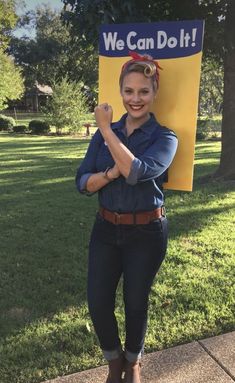 a woman standing in front of a sign with the words we can do it