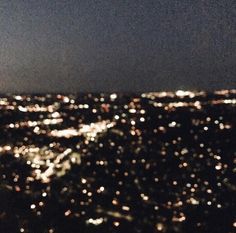 the city lights shine brightly at night from an aerial view point in the dark sky