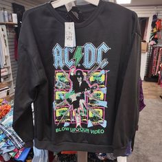 an ac / dc t - shirt is on display in a clothing store for sale