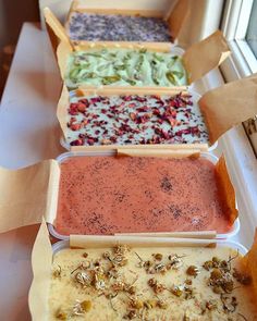 four different types of dips are lined up on a window sill in their trays