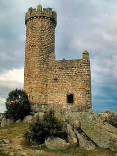 an old stone castle sitting on top of a hill