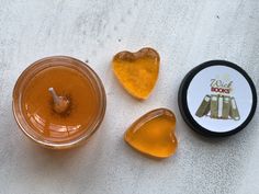 two jars filled with honey sitting next to each other on a white tablecloth covered surface