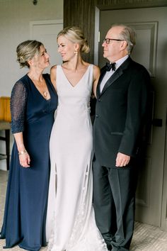 three people standing next to each other in formal wear