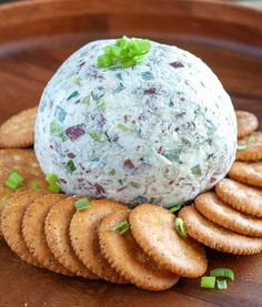 a cheese ball on top of crackers with green garnish