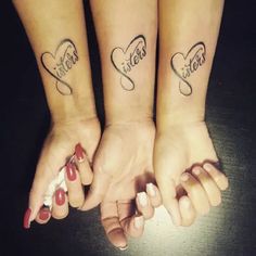 two girls with matching tattoos on their arms holding hands and the words sisters written in cursive letters