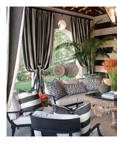 the living room is decorated in black and white striped furniture, with palm trees on either side