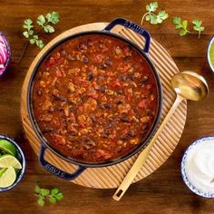 chili con carne with tortilla chips and limes on the side next to it