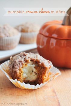 some muffins are sitting on a table next to a potted orange pumpkin