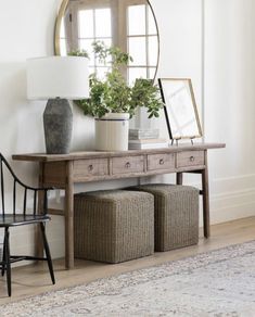 a room with a table, mirror and two stools