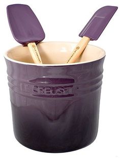 two wooden spatulas in a purple plastic container