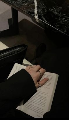 a person sitting at a table reading a book