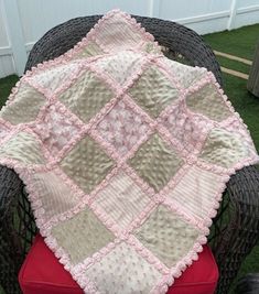 a chair with a blanket on top of it in the grass next to a fence