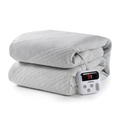 an alarm clock sitting on top of two blankets next to each other with thermometer attached