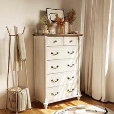 a white dresser sitting next to a window