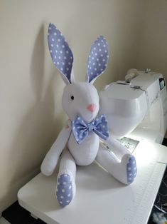 a stuffed rabbit sitting on top of a sewing machine