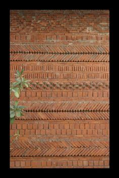 a brick wall with some plants growing out of it's sides and the bottom