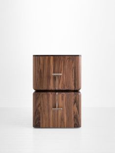 two wooden boxes stacked on top of each other in front of a white wall and floor