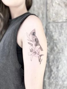 a woman's arm with a bird and flowers tattoo on the left upper arm