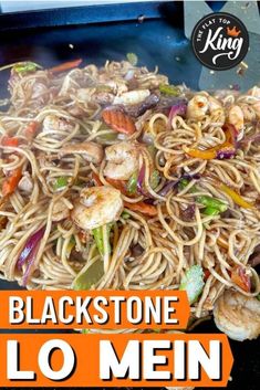 noodles with shrimp and vegetables on a black plate