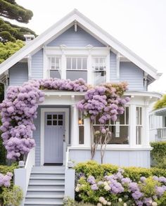 a blue house with purple flowers on the front