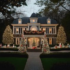 a large house decorated with christmas lights and trees