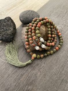 This stylish long beaded necklace is a Mala bead necklace, made with Unakite beads, white beads, small shiny beads and a earth green tassel hanging at the bottom. A Mala necklace that will keep you in style and grounded at the same time. Use it as a necklace, for meditating, as a bracelet, or a decor item. The necklace drop length is The tassel is... A most have addition to your Mala collection. ⚡️Join Akashi's VIP list for early bird discount access⚡️ Paste into your browser http://eepurl.com/h Bohemian 8mm Beads For Jewelry Making, 8mm Bohemian Beads For Jewelry Making, Bohemian Beaded Necklaces With 8mm Beads For Jewelry Making, Bohemian Round Beads For Jewelry Making, Earthy Beaded Necklace With 108 Beads For Healing, Hand-strung Lariat Beads For Gift, Lariat Necklace With 108 Beads For Meditation, Bohemian Beaded Mala, Hand-strung Lariat Beads As A Gift