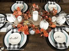 the table is set for thanksgiving dinner with white pumpkins and black checkered plates