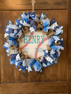 a baseball wreath with the name henry on it hanging from a door frame in front of a wooden wall