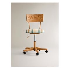 a wooden chair with wheels and a plaid seat pad