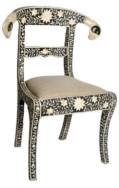 an ornately decorated chair with white flowers on it's back and seat, against a white background