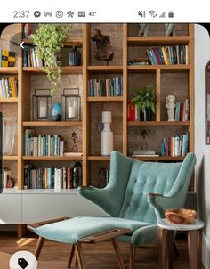 a living room filled with lots of bookshelves next to a chair and table