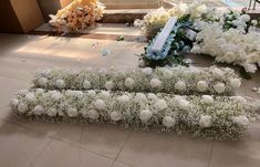 flowers and candles are laid out on the floor in front of a staircase at a church