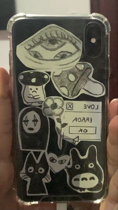 someone holding up their phone case with stickers on it