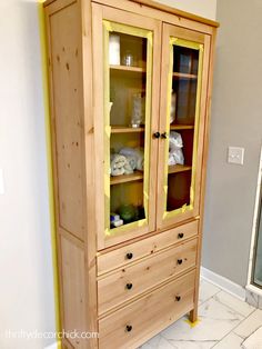 a wooden cabinet with glass doors in a bathroom