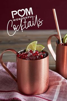 two copper mugs filled with pomegranate and lime