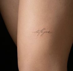 a woman's thigh with the word love written on it in cursive handwriting