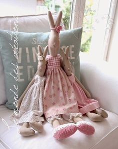 two stuffed animals sitting on top of a white couch next to pillows and slippers