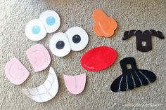 paper cut outs with eyes, nose and mouth on carpeted area next to wall