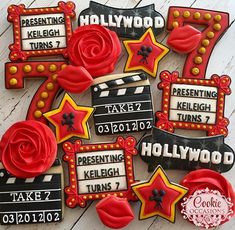 decorated cookies with hollywood themed decorations on top of a white wooden table next to a red rose