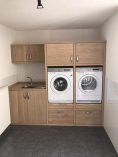 a washer and dryer sitting in a kitchen next to each other on top of cabinets