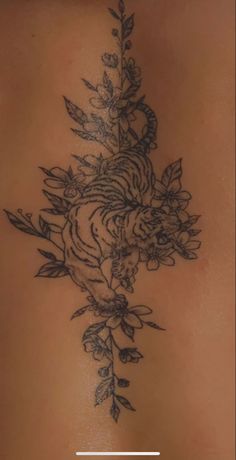 the back of a woman's stomach with flowers on it and an arrow in the middle