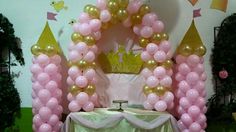 a table topped with pink and gold balloons