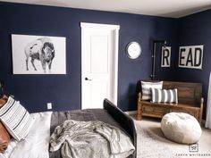 a bed room with a neatly made bed and pictures hanging on the wall above it