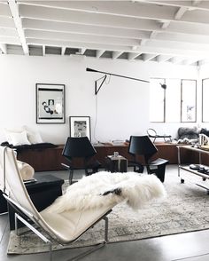 a living room filled with lots of furniture and pictures hanging on the wall above it